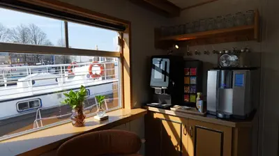 a room with a window and a desk with a refrigerator at Botel Clair d'Etoile in Amsterdam