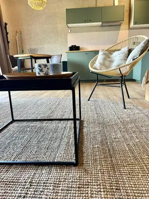 a living room with a coffee table and a chair at Saltéa Beach House Noordwijk in Noordwijk aan Zee