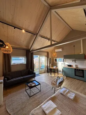 a living room with a couch and a table at Saltéa Beach House Noordwijk in Noordwijk aan Zee