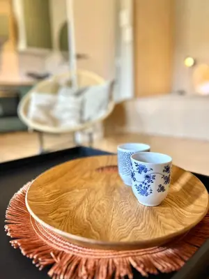 two cups sitting on a wooden plate on a table at Saltéa Beach House Noordwijk in Noordwijk aan Zee