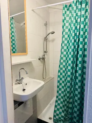 a bathroom with a sink and a shower curtain at Het zandhuisje 84 in Noordwijk aan Zee