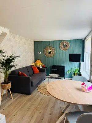 a living room with a couch and a table at Het zandhuisje 84 in Noordwijk aan Zee