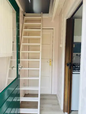 a spiral staircase in a tiny house at Het zandhuisje 84 in Noordwijk aan Zee