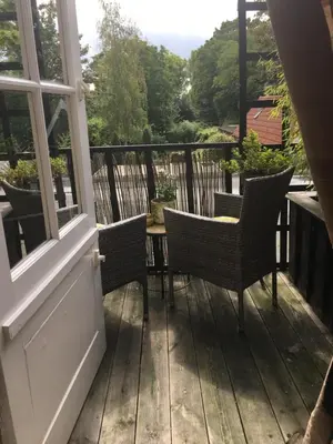 a porch with chairs and a table on a balcony at Agapanthus bed and breakfast in Hoogkarspel