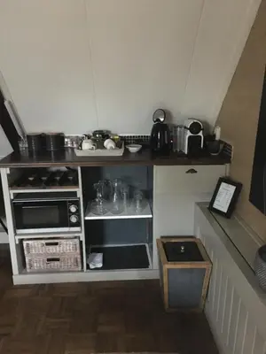a small kitchen with a stove and a microwave at Agapanthus bed and breakfast in Hoogkarspel