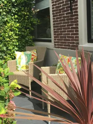 two chairs with pillows sitting on a porch at Agapanthus bed and breakfast in Hoogkarspel