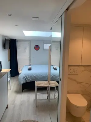 a small bedroom with a bed and a toilet at Studio South Beach II with free parking in Zandvoort