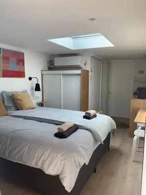 a bedroom with a large bed with towels on it at Studio South Beach II with free parking in Zandvoort