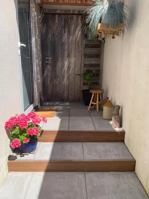 a patio with two potted plants and a door at Studio South Beach II with free parking in Zandvoort