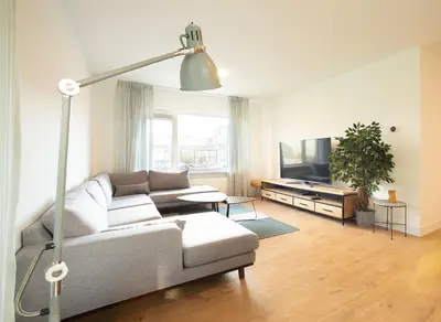 a living room with a couch and a flat screen tv at NEW! Nightglow Residency in Oosteinde