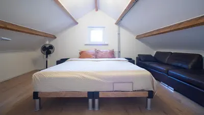 a bedroom with a bed and a couch at NEW! Nightglow Residency in Oosteinde