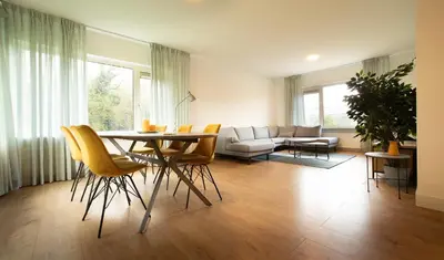 a living room with a table and chairs and a couch at NEW! Nightglow Residency in Oosteinde