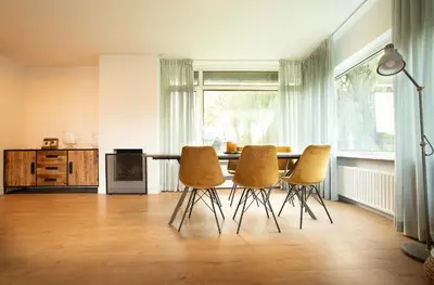 a dining room with a table and yellow chairs at NEW! Nightglow Residency in Oosteinde