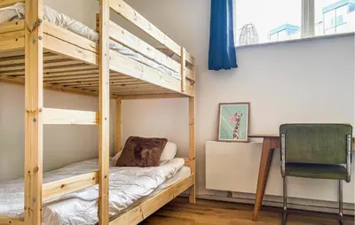 a bedroom with bunk beds with a desk and a chair at Nice Apartment In Bergen Aan Zee in Bergen aan Zee