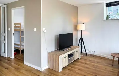 a living room with a flat screen tv on a stand at Nice Apartment In Bergen Aan Zee in Bergen aan Zee