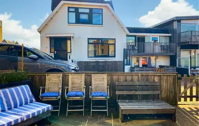 a group of chairs and a bench in front of a house at Nice Apartment In Bergen Aan Zee in Bergen aan Zee