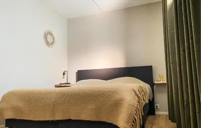 a bedroom with a bed with a brown blanket at Nice Apartment In Bergen Aan Zee in Bergen aan Zee