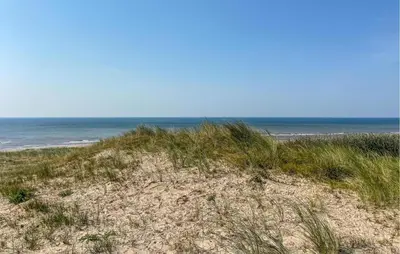 a sandy beach with the ocean in the background at 1 Bedroom Awesome Home In Katwijk Aan Zee in Katwijk aan Zee