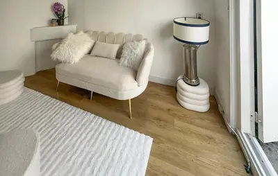 a living room with a chair and a lamp at 1 Bedroom Awesome Home In Katwijk Aan Zee in Katwijk aan Zee