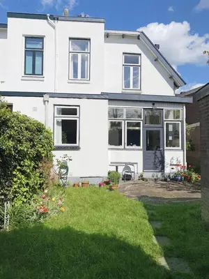 a white house with a lawn in front of it at Authentic villa near Amsterdam and nature in Ons Belang