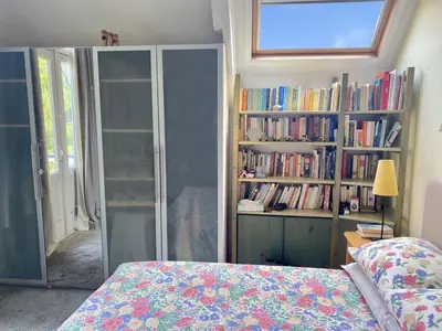 a bedroom with a bed and a book shelf with books at Authentic villa near Amsterdam and nature in Ons Belang