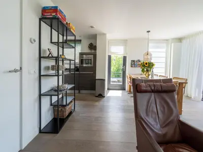a living room with a leather chair and a table at Villa in Egmond near Beach & Windmill in Egmond aan den Hoef