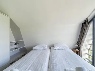 two beds in a room with a window at Villa in Egmond near Beach & Windmill in Egmond aan den Hoef