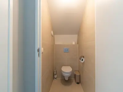 a small bathroom with a toilet in a attic at Villa in Egmond near Beach & Windmill in Egmond aan den Hoef