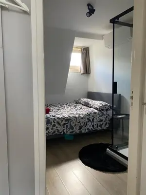 a small bedroom with a bed and a window at Rooftop Terrace Apartment in Amsterdam