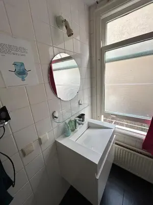 a bathroom with a sink and a mirror and a window at michelle in Amsterdam