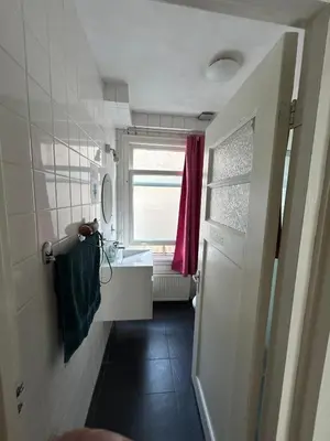 a small bathroom with a sink and a window at michelle in Amsterdam