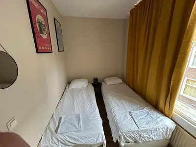 two beds in a small room with a window at michelle in Amsterdam