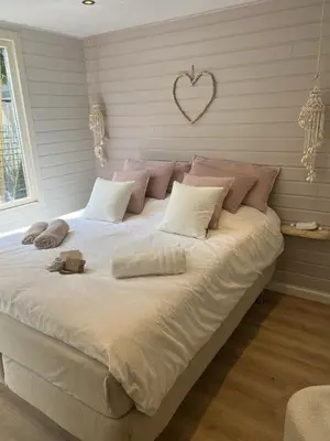a large bed with pillows and a heart on the wall at Zandvoort Boutique Apartments in Zandvoort