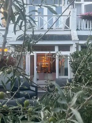 a white house with a table in a window at Zandvoort Boutique Apartments in Zandvoort