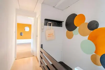 a hallway with a white wall with colorful circles on it at Stay de Laat in Alkmaar