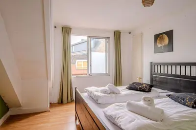 two twin beds in a room with a window at Stay de Laat in Alkmaar