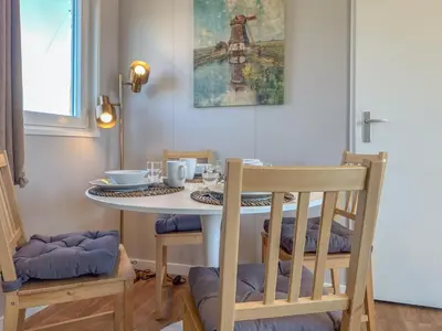 a dining room with a table and chairs and a cross painting at Fuut 24-28 in Breukelen