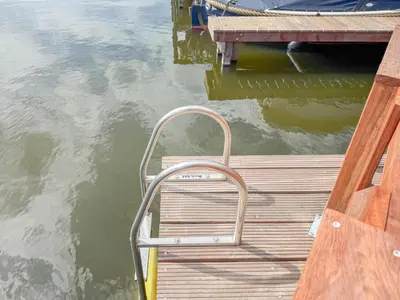 a metaladder sitting on a dock next to the water at Fuut 24-28 in Breukelen
