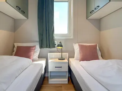 two beds in a small room with a window at Fuut 24-26 in Breukelen
