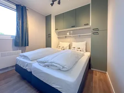 a bedroom with a bed with white sheets and pillows at Fuut 24-26 in Breukelen
