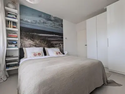 a bedroom with a bed and a painting on the wall at Studio Lumare-Inn in Bergen aan Zee