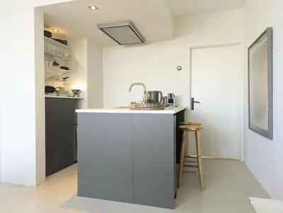 a kitchen with a white counter and a sink at Studio Lumare-Inn in Bergen aan Zee