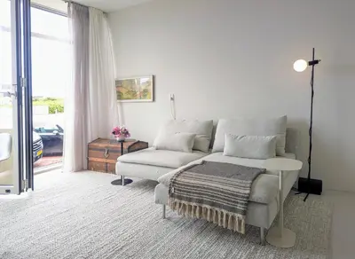 a living room with a couch and a chair at Studio Lumare-Inn in Bergen aan Zee