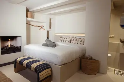 a white bedroom with a bed and a fireplace at Luxury canal suite in the best location of Amsterdam !!! in Amsterdam