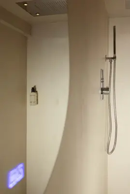 a white wall with a shower in a bathroom at Luxury canal suite in the best location of Amsterdam !!! in Amsterdam