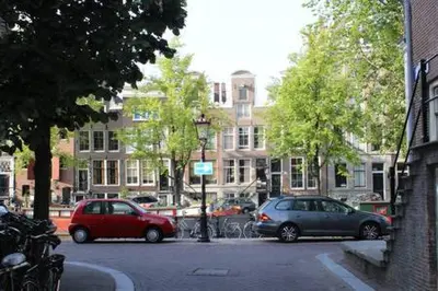 two cars parked in a parking lot in a city at Luxury canal suite in the best location of Amsterdam !!! in Amsterdam