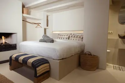 a white bedroom with a bed and a fireplace at Luxury canal suite in the best location of Amsterdam !!! in Amsterdam