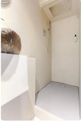 a room with a shower in a white wall at Luxury canal suite in the best location of Amsterdam !!! in Amsterdam