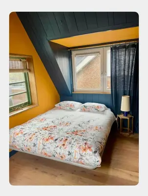 a bed in a room with a window at House next to Amsterdam in Landsmeer