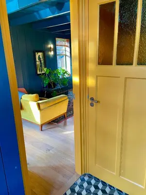 a room with a yellow door and a yellow chair at House next to Amsterdam in Landsmeer